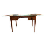 Elegant antique desk in cherry wood with a black leather top and glass plate.