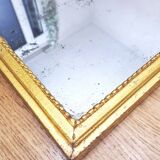 Old mercury mirror in carved wood, gilded with leaf.