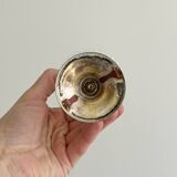 Small vase on a metal stand with thick glass.