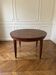 Oval extendable dining table in wood and walnut burl veneer.