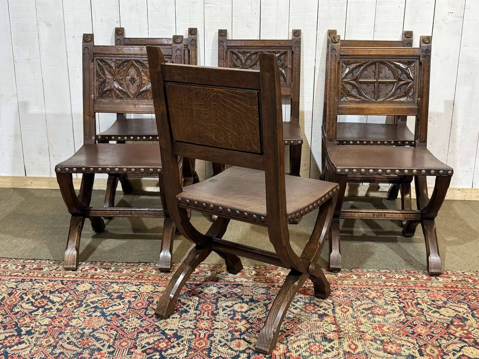 Suite de 6 chaises et 2 fauteuils en chêne et cuir à décor gothique