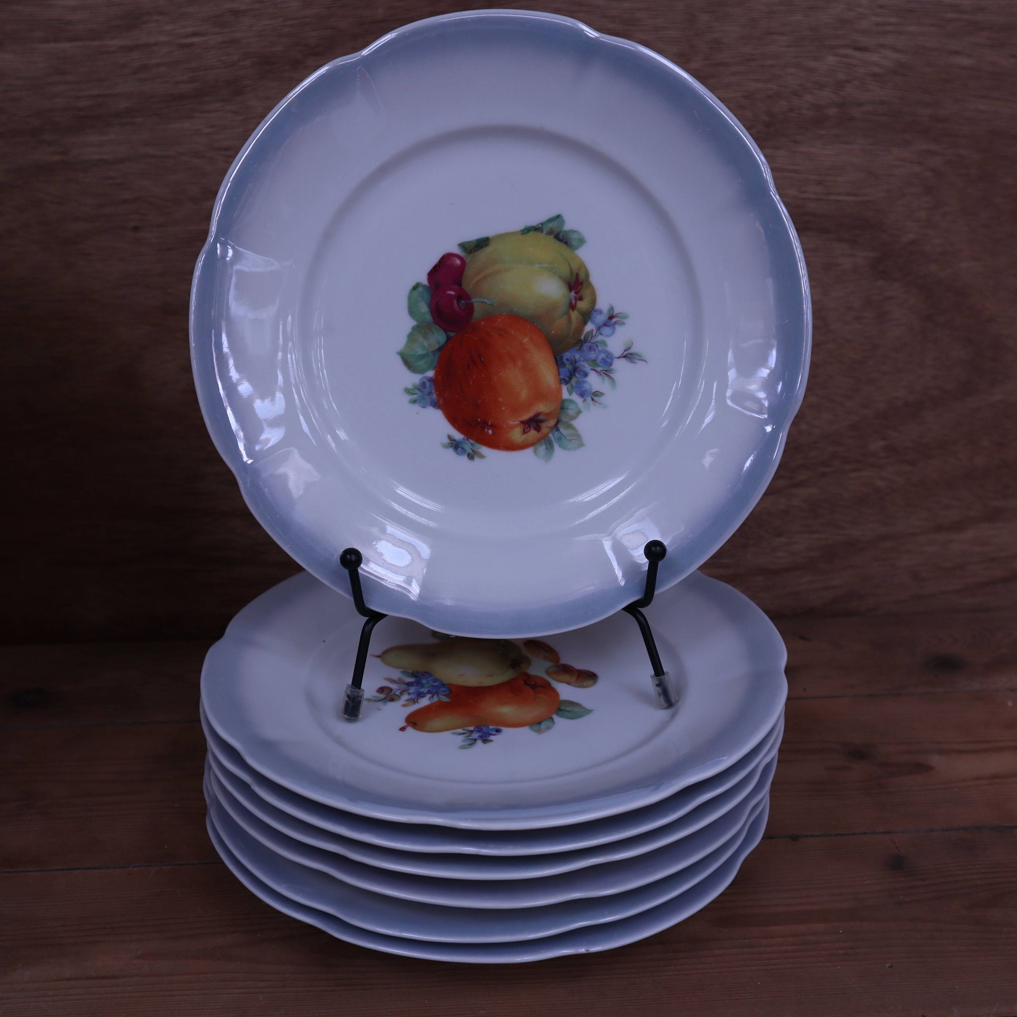 Set of 7 dessert plates and a cake stand with fruit patterns.
