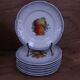 Set of 7 dessert plates and a cake stand with fruit patterns.