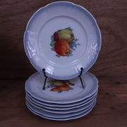 Set of 7 dessert plates and a cake stand with fruit patterns.