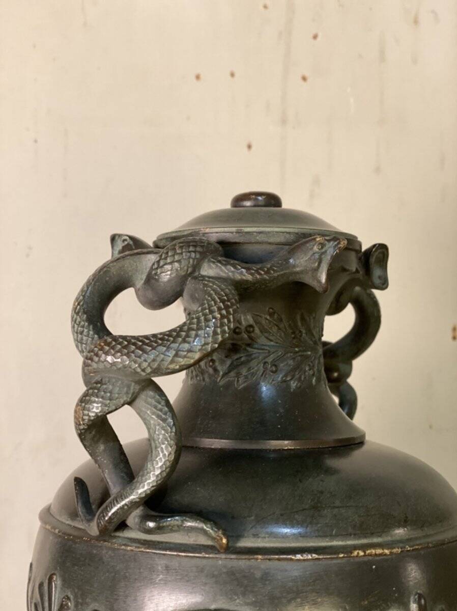 Bronze vase with snakes and a green patina, in the antique style.