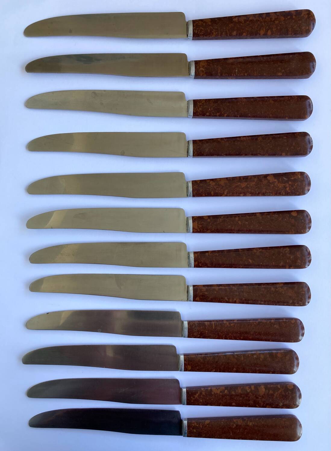12 table knives stainless steel blade round ends / Bakelite handles with wood burl effect / 1950s