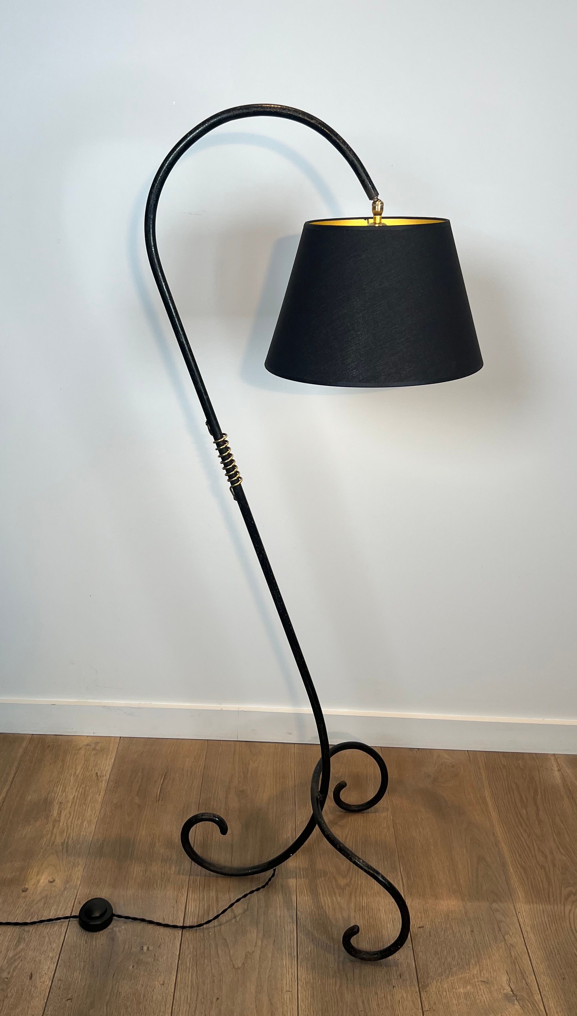 Design floor lamp in black lacquered metal and brass.