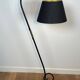 Design floor lamp in black lacquered metal and brass.