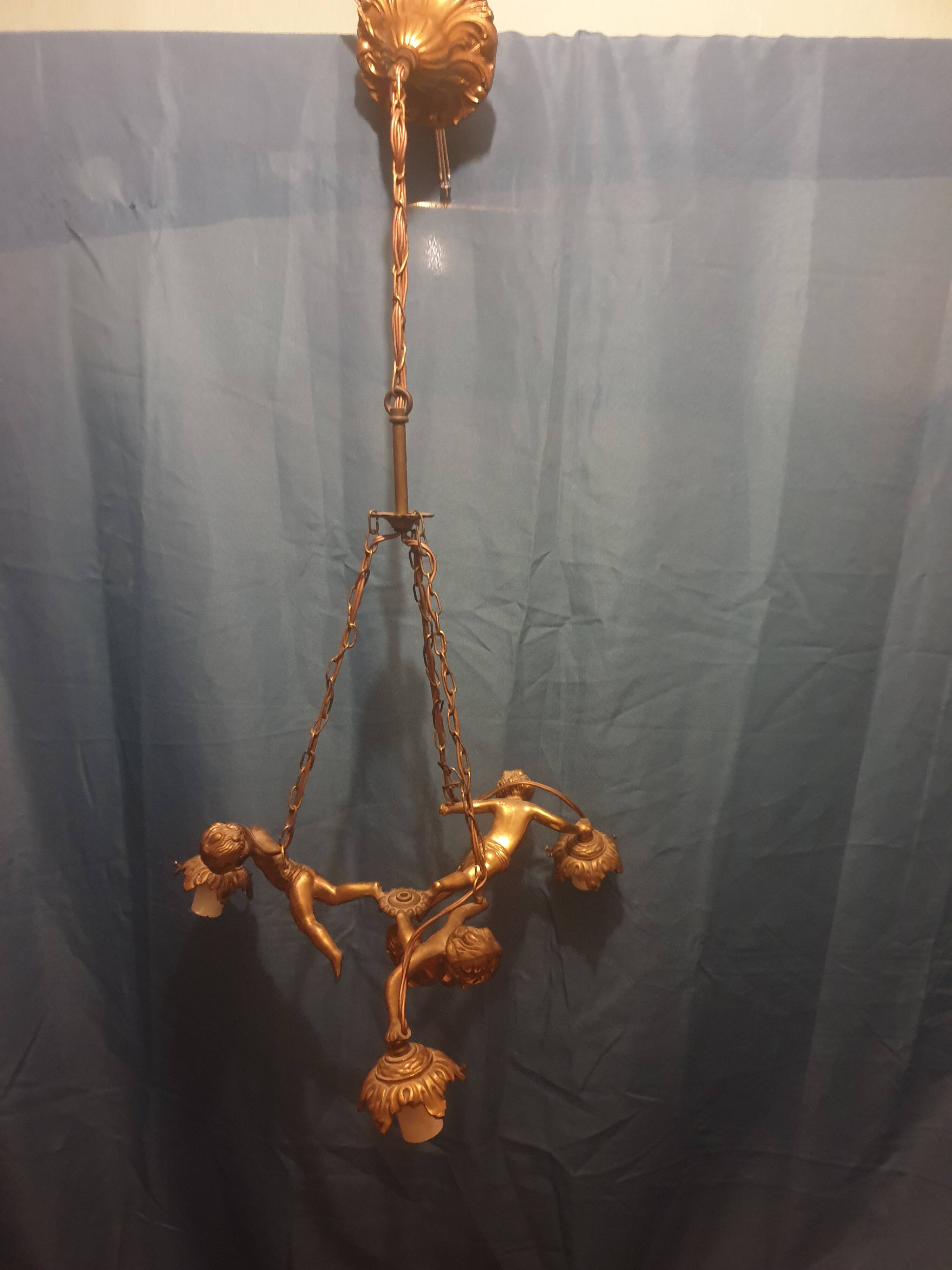 Antique chandelier decorated with cherubs and putti angels taken from the attic