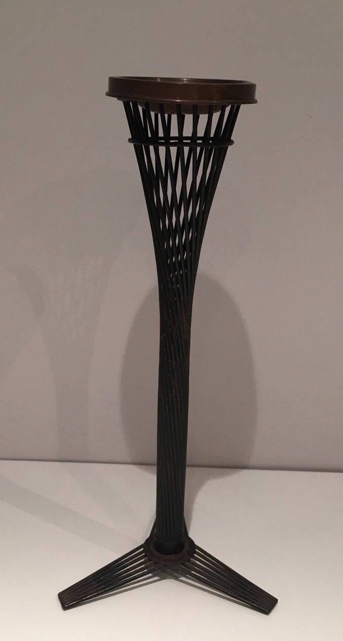Brass ashtray on a stand made of black lacquered metal wire.