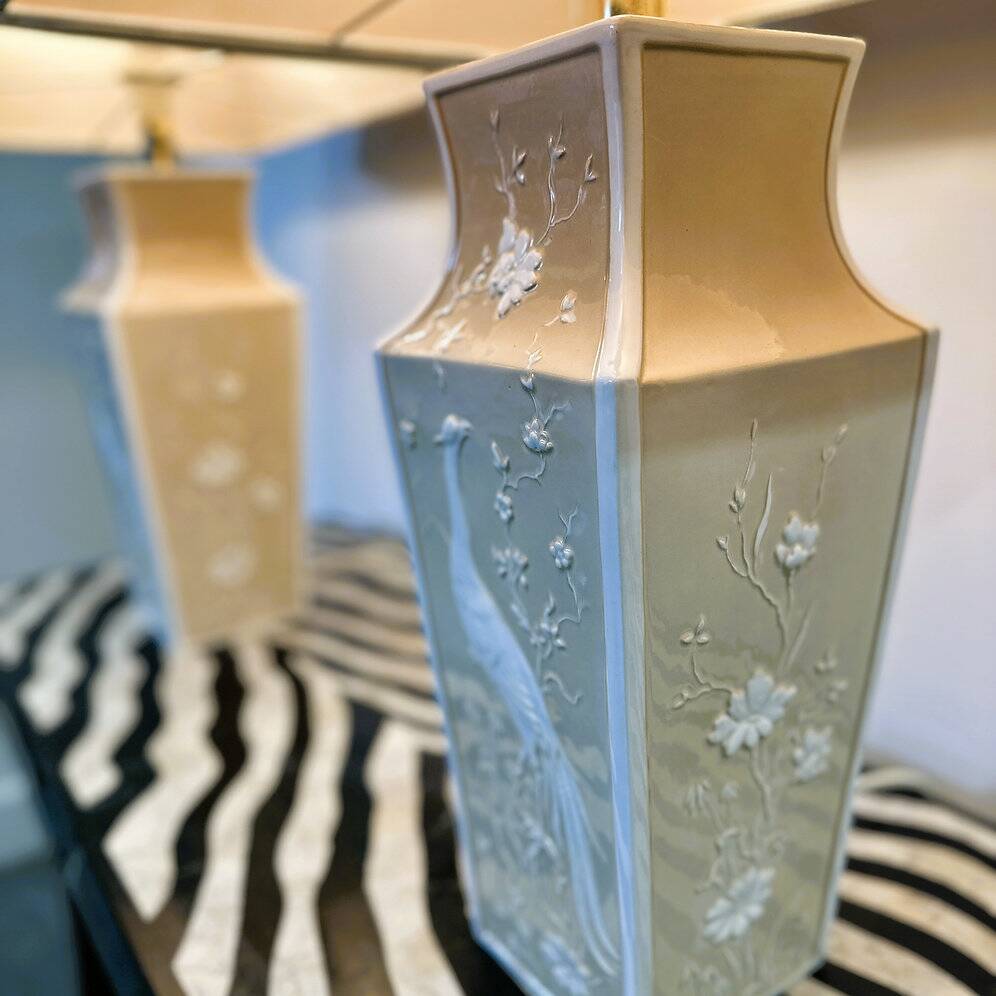 Pair of large cream ceramic table lamps with relief peacocks and fabric shades