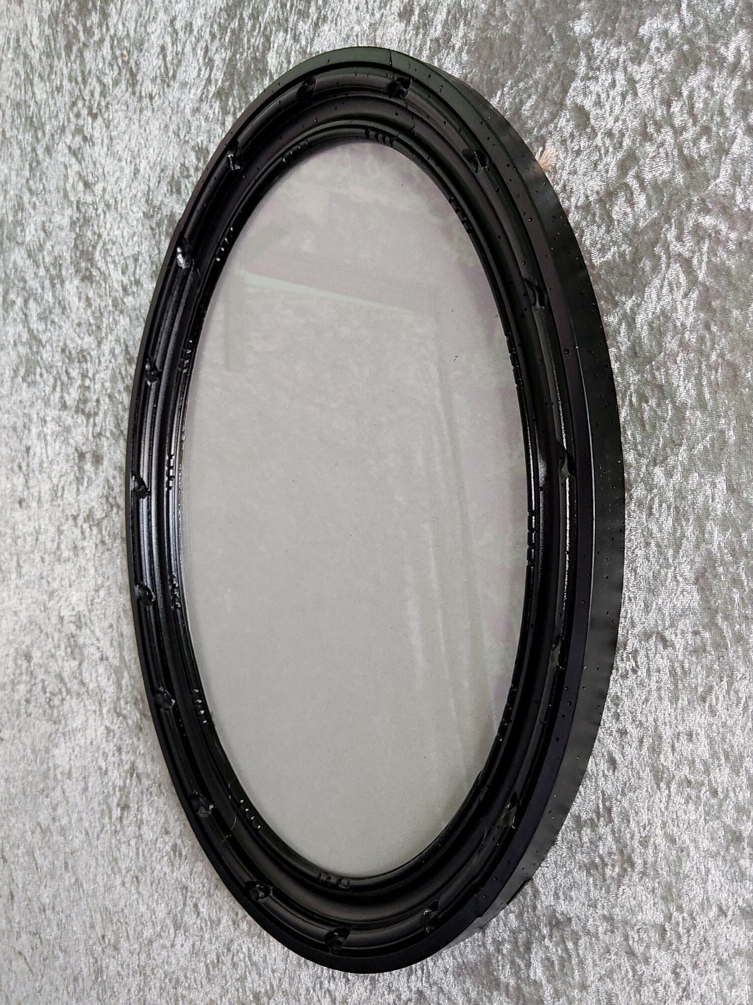 Oval frame in black varnished carved wood
