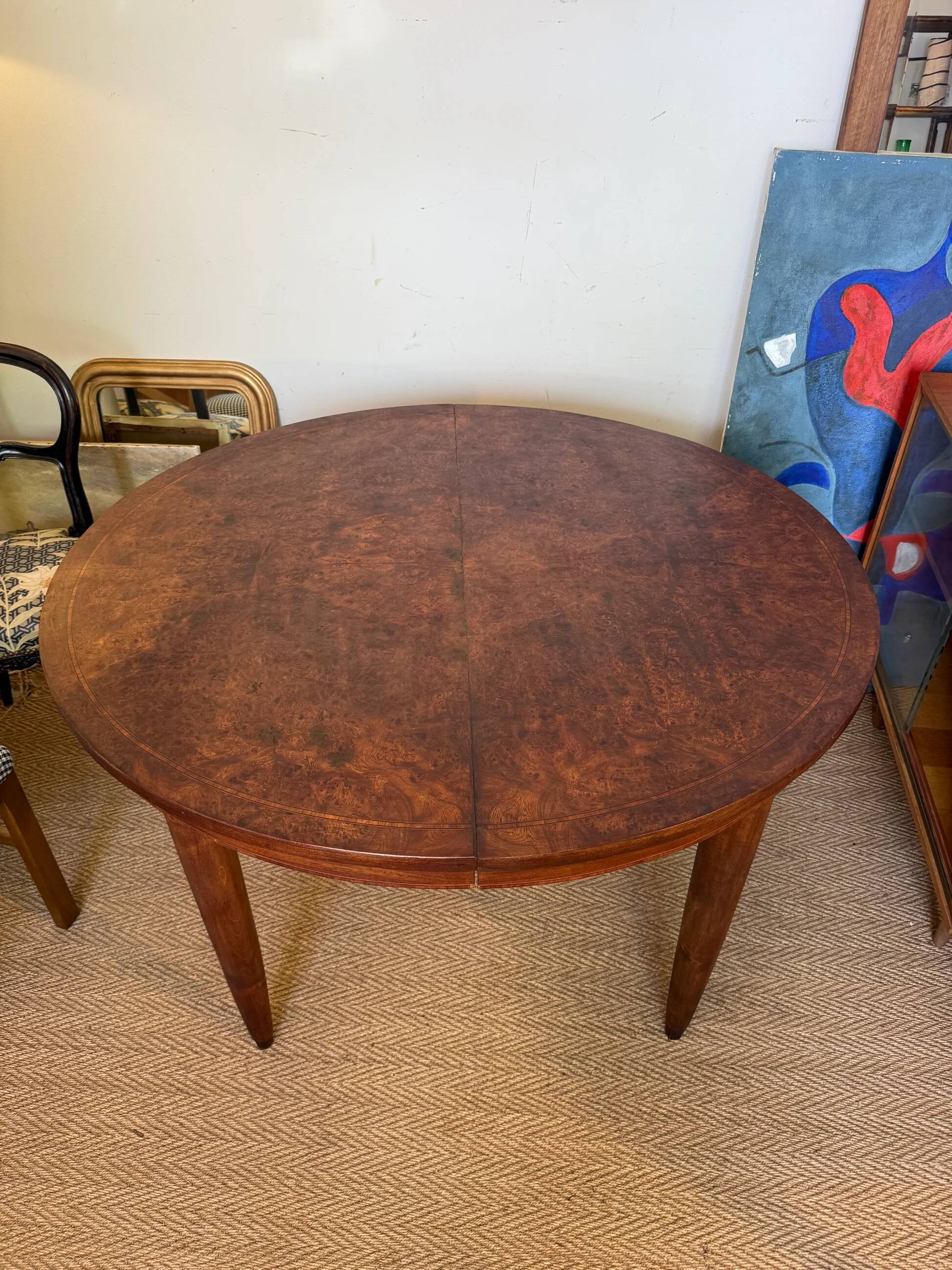 Oval extendable dining table in wood and walnut burl veneer.