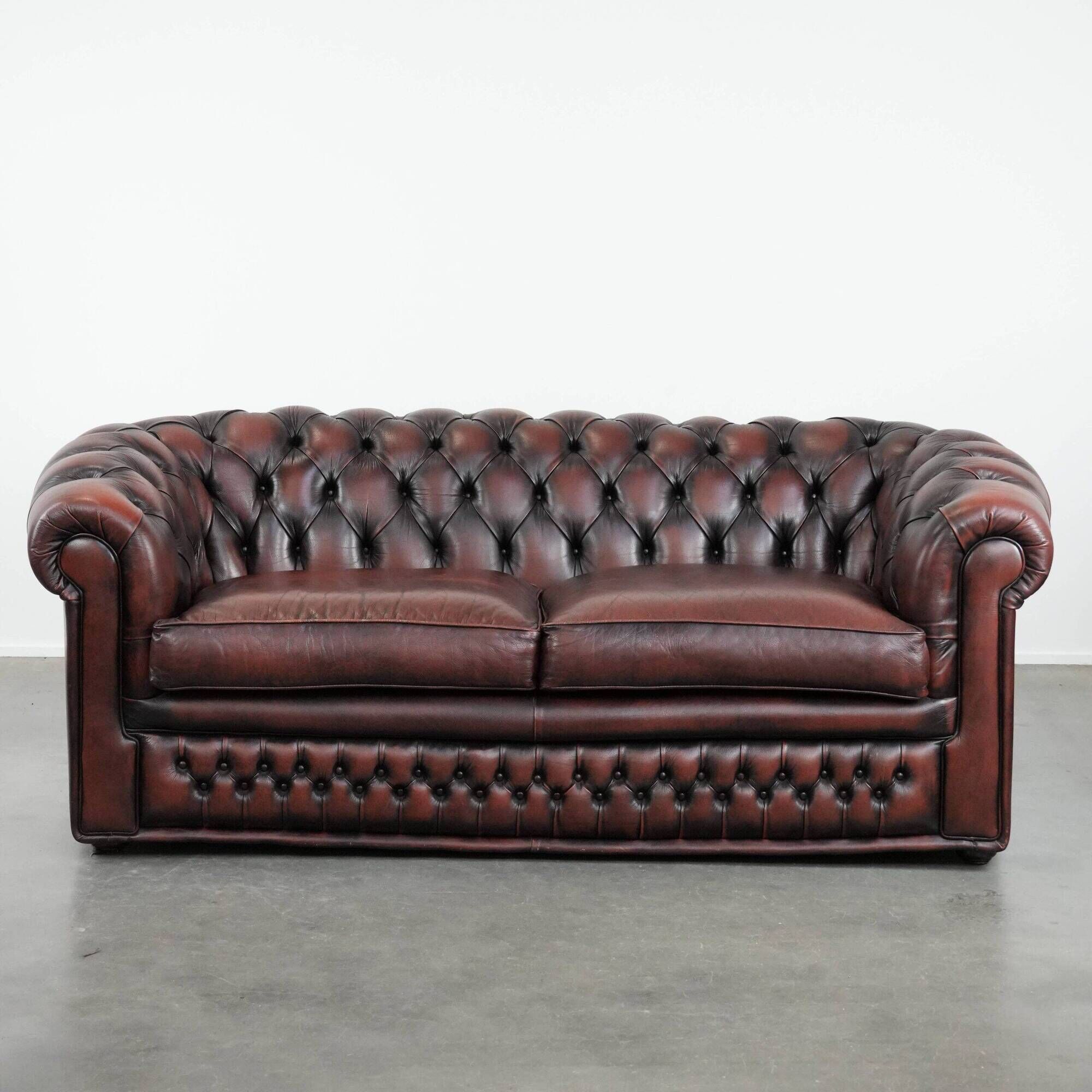 Classic cowhide Chesterfield sofa in English style with red/brown colours