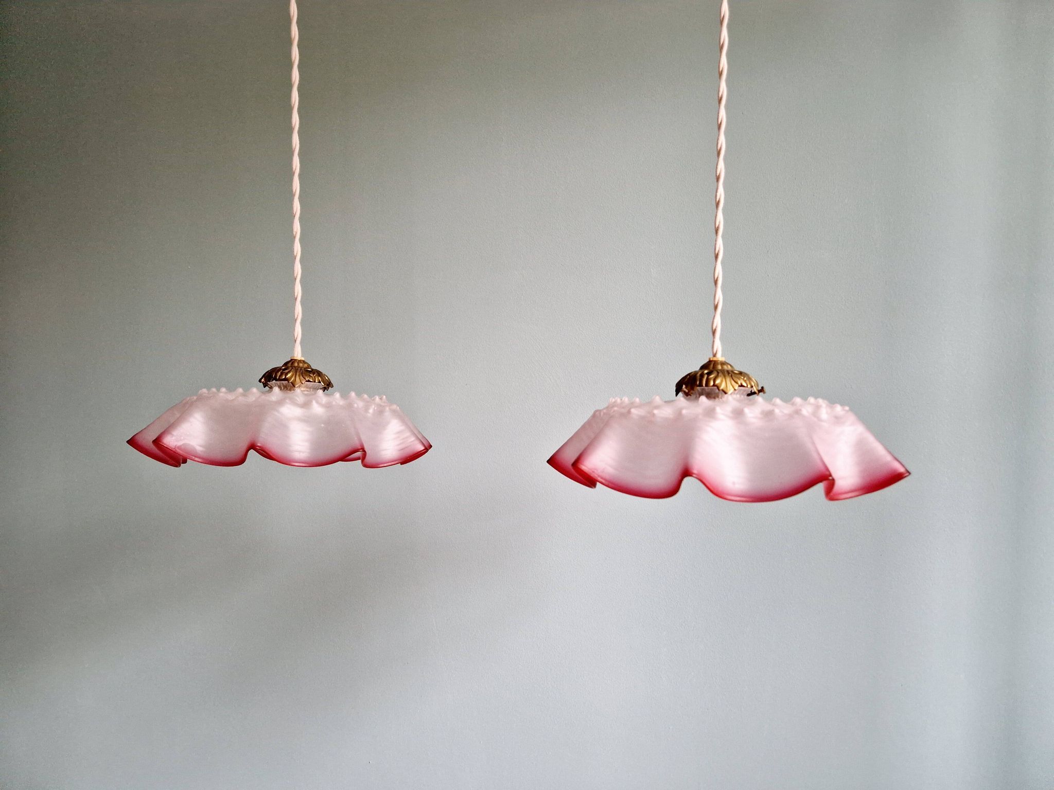 Pair of clear and pink satin glass scalloped pendant lights, 1920s-30s