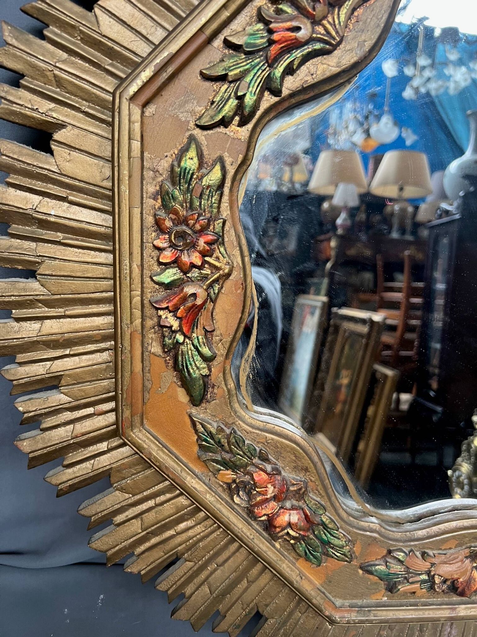 Large wooden mirror with golden sun rays, in Art Deco style.