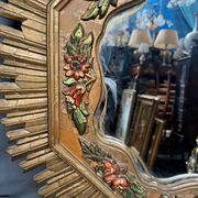 Large wooden mirror with golden sun rays, in Art Deco style.