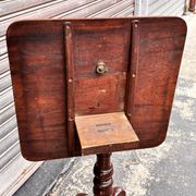 19th-century solid mahogany table with a tilting top and brass mechanism.