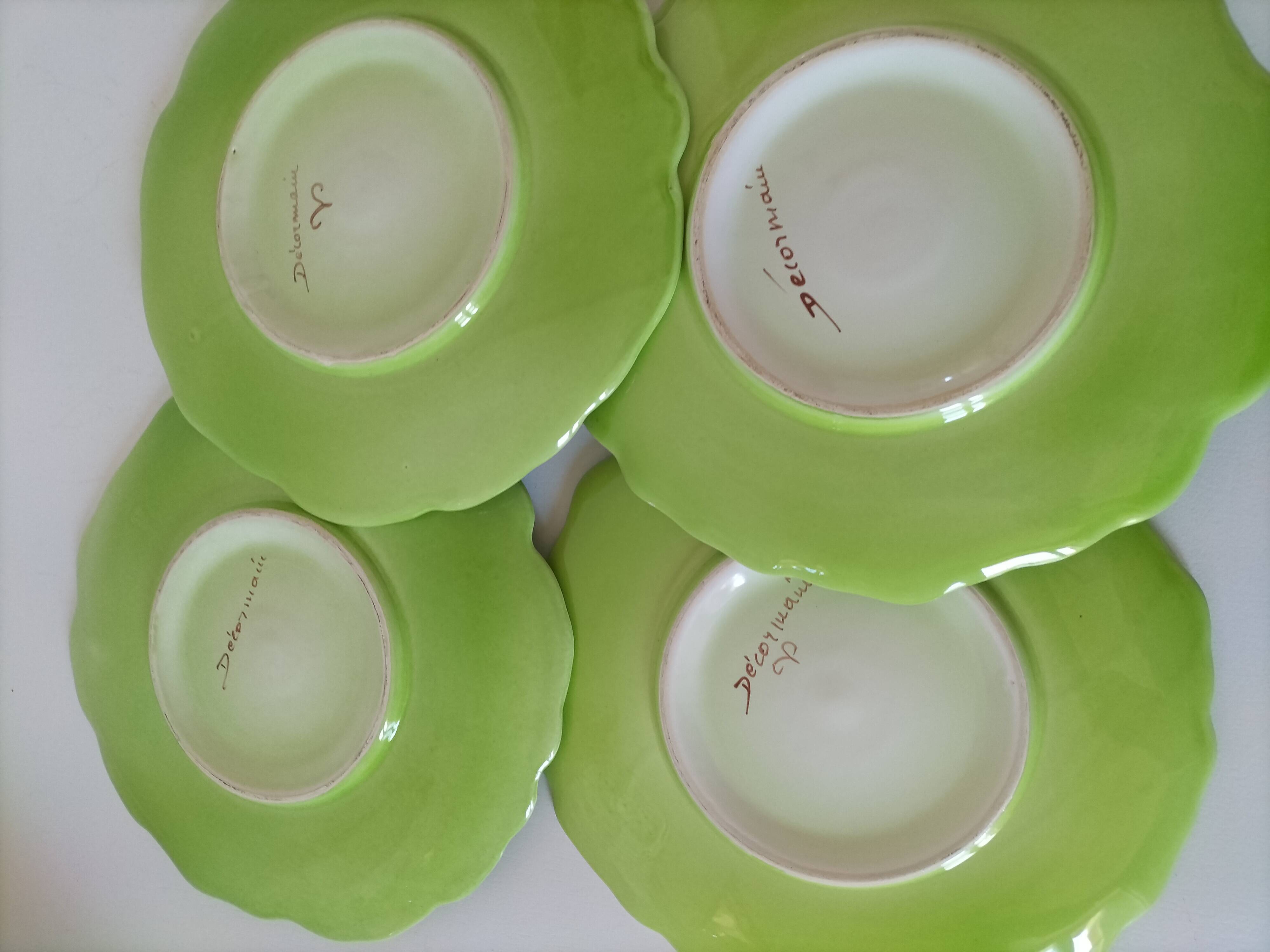 4 hand-decorated earthenware plates with vegetable and green leaf designs.