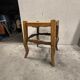 Rustic wooden stool with a straw seat.