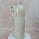 Antique beige glazed stoneware bottle from the 19th century, with a handle, vintage decor.
