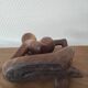 Wooden sculpted statuette of a woman in a pensive pose.