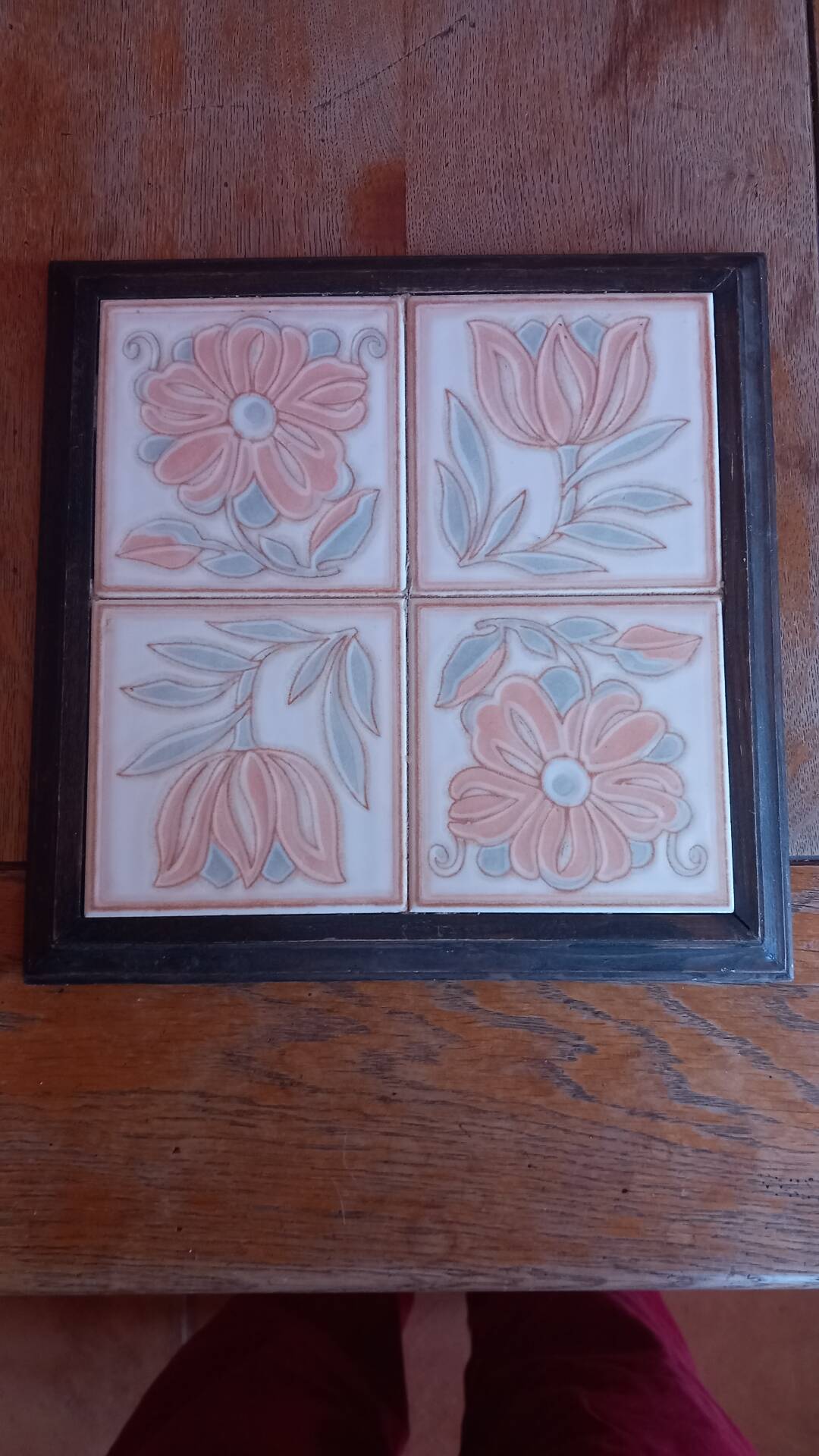Ceramic tile trivet with floral patterns in pastel tones.