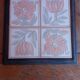 Ceramic tile trivet with floral patterns in pastel tones.