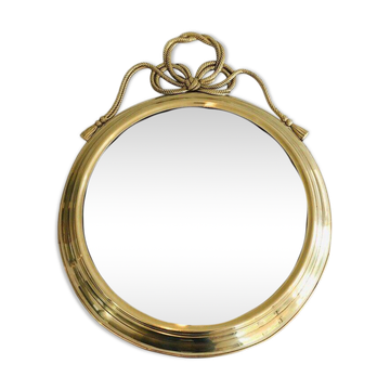 Large decorative oval mirror in brass adorned with a significant twisted bow.