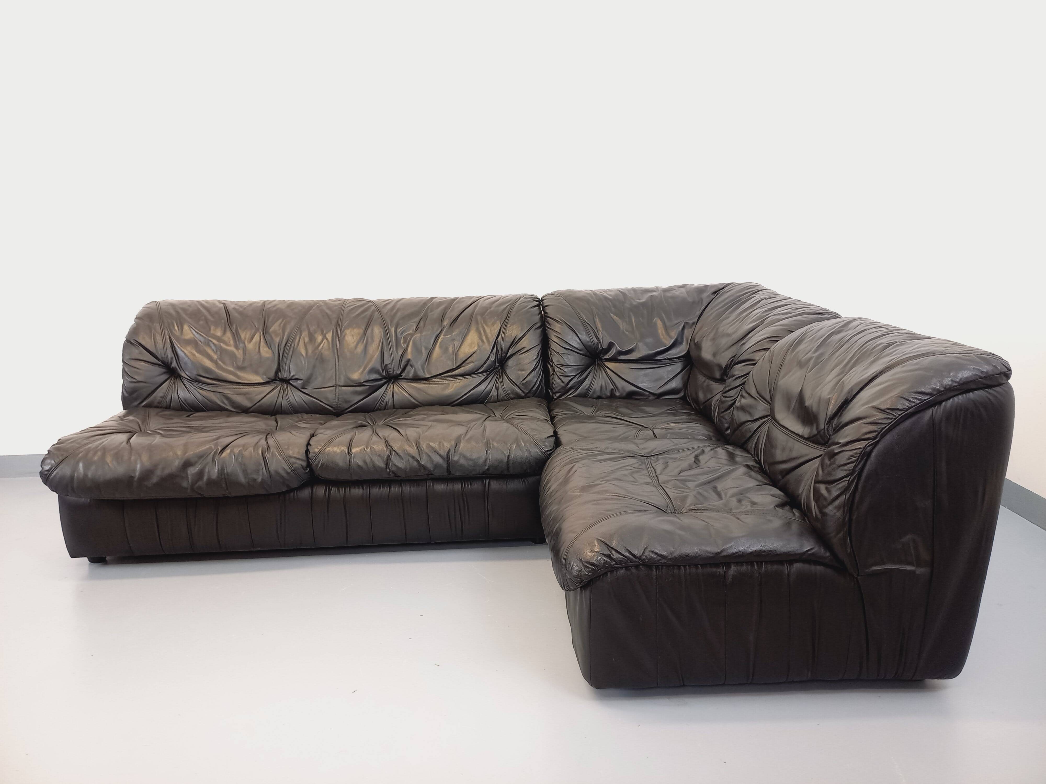 Vintage corner sofa composed of 3 modules in black leather with integrated bed.