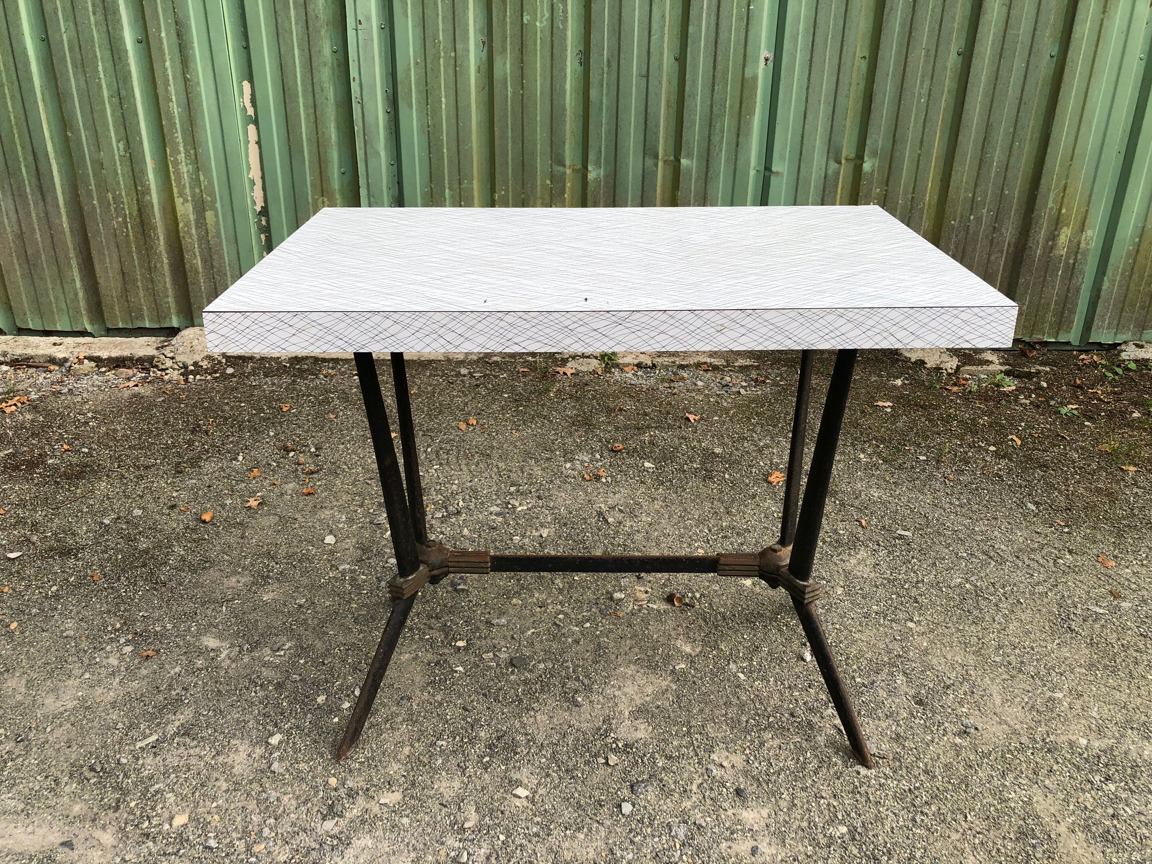 Vintage bistro table with an Art Deco style cast iron base and Formica top.