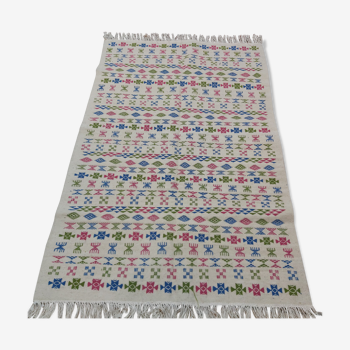 White carpet with Berber motifs pink green and blue