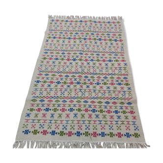 White carpet with Berber motifs pink green and blue