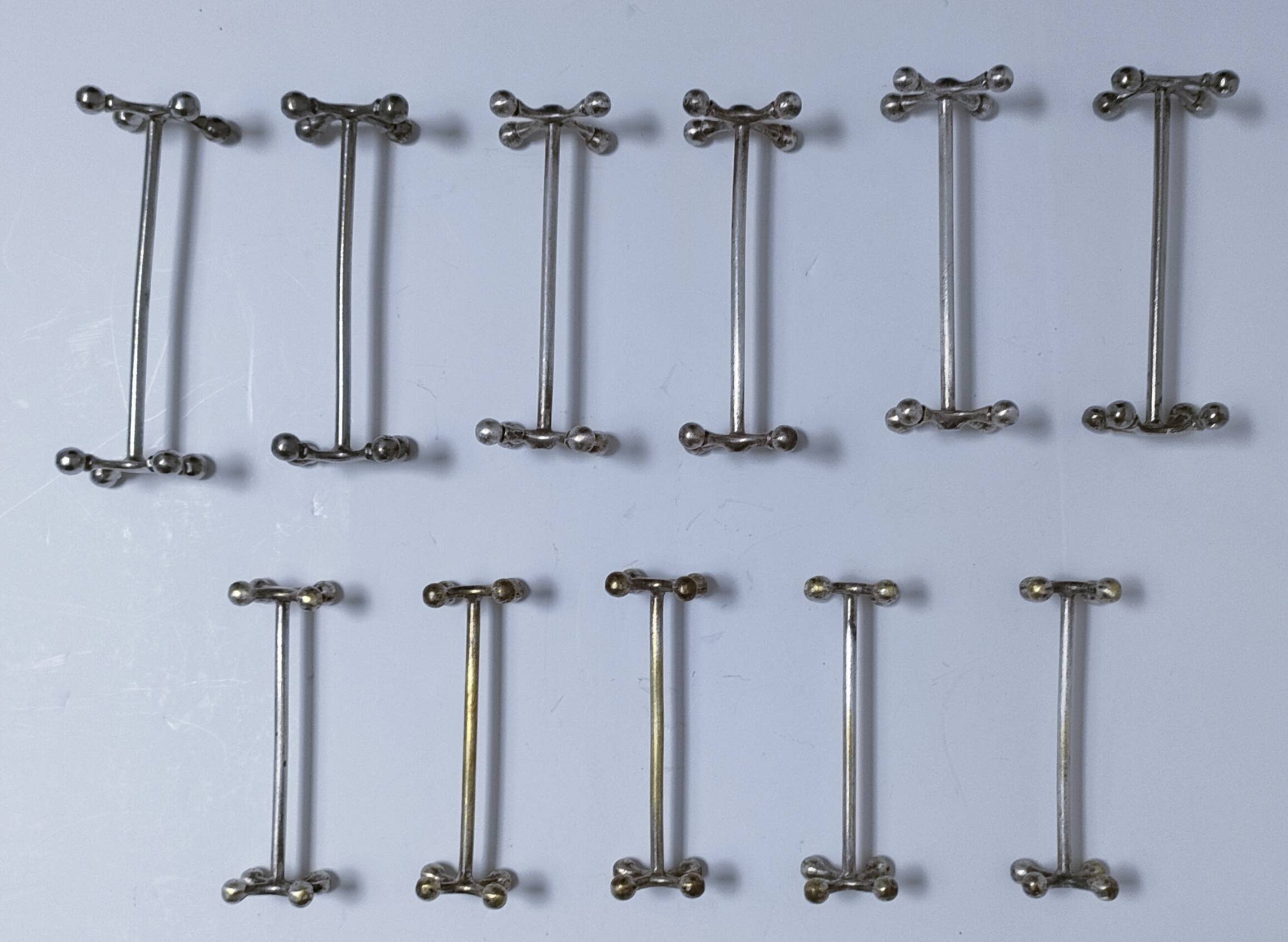 Eleven 70s design metal "crosshair" knife holders