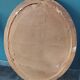 Antique oval mirror in a carved and painted frame with a floral panel.