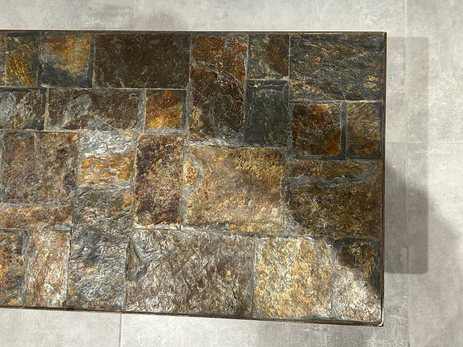 Brutalist-style coffee table made of mixed wrought iron and stone.