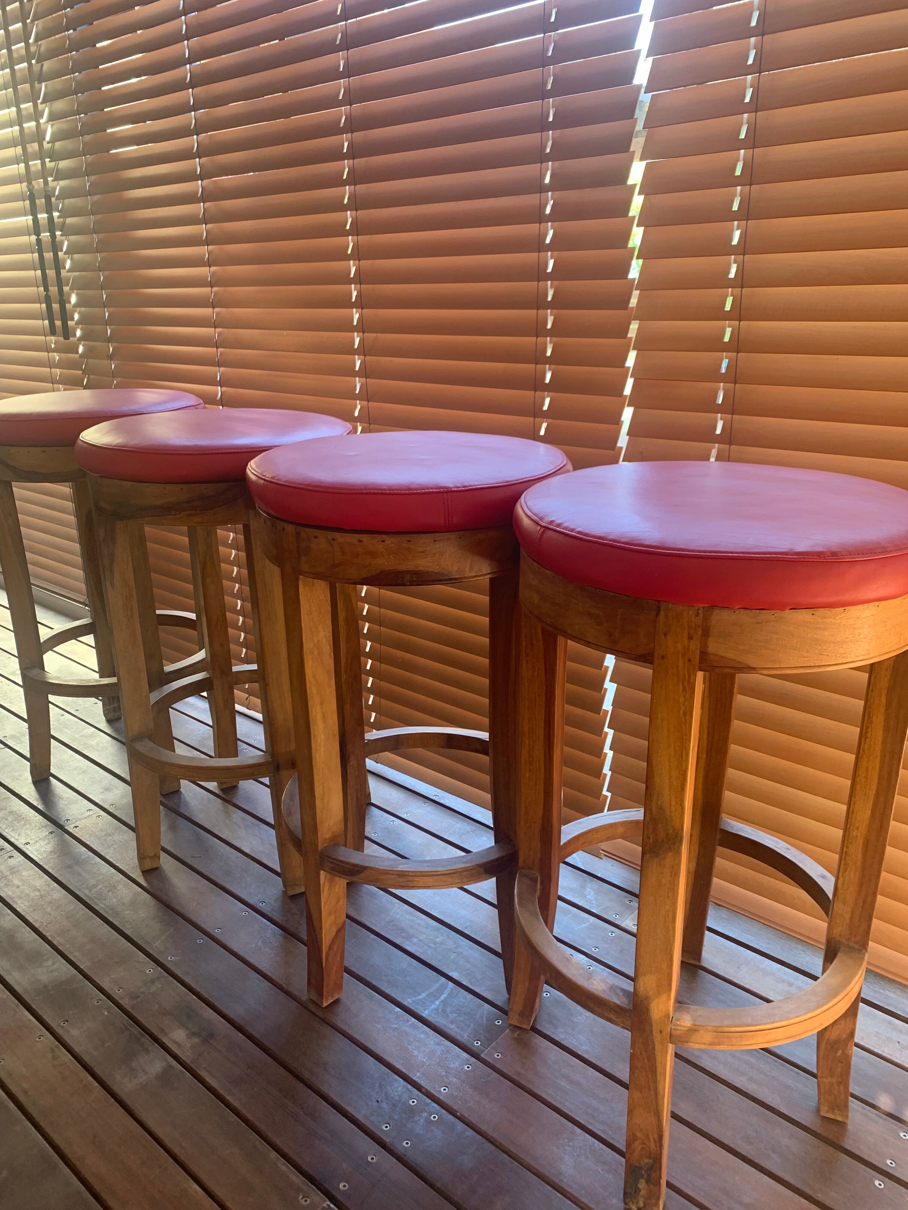 Set of 4 bar stools in solid exotic wood and red leather.