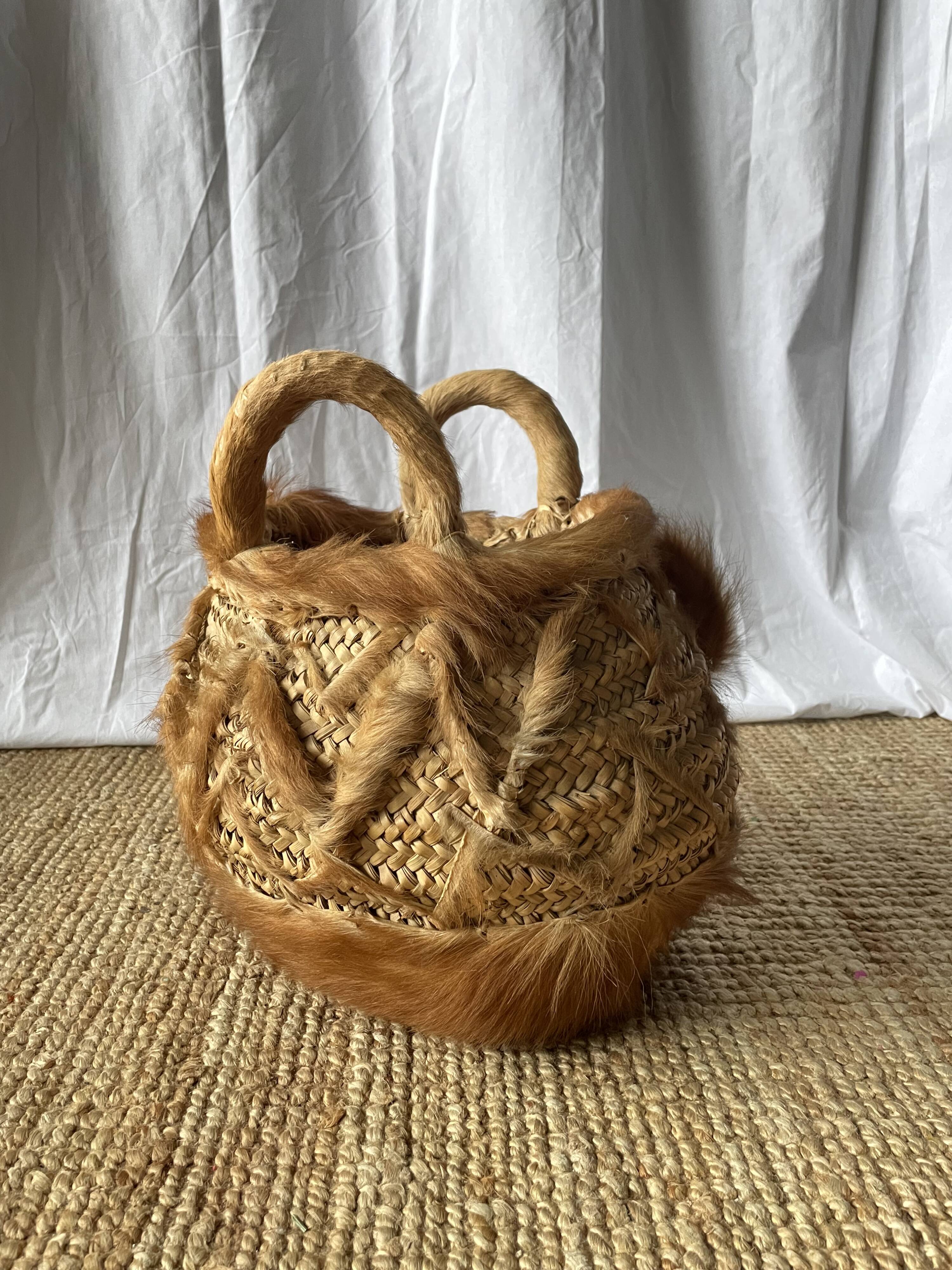 Handwoven vintage basket with handles made from natural fibres.