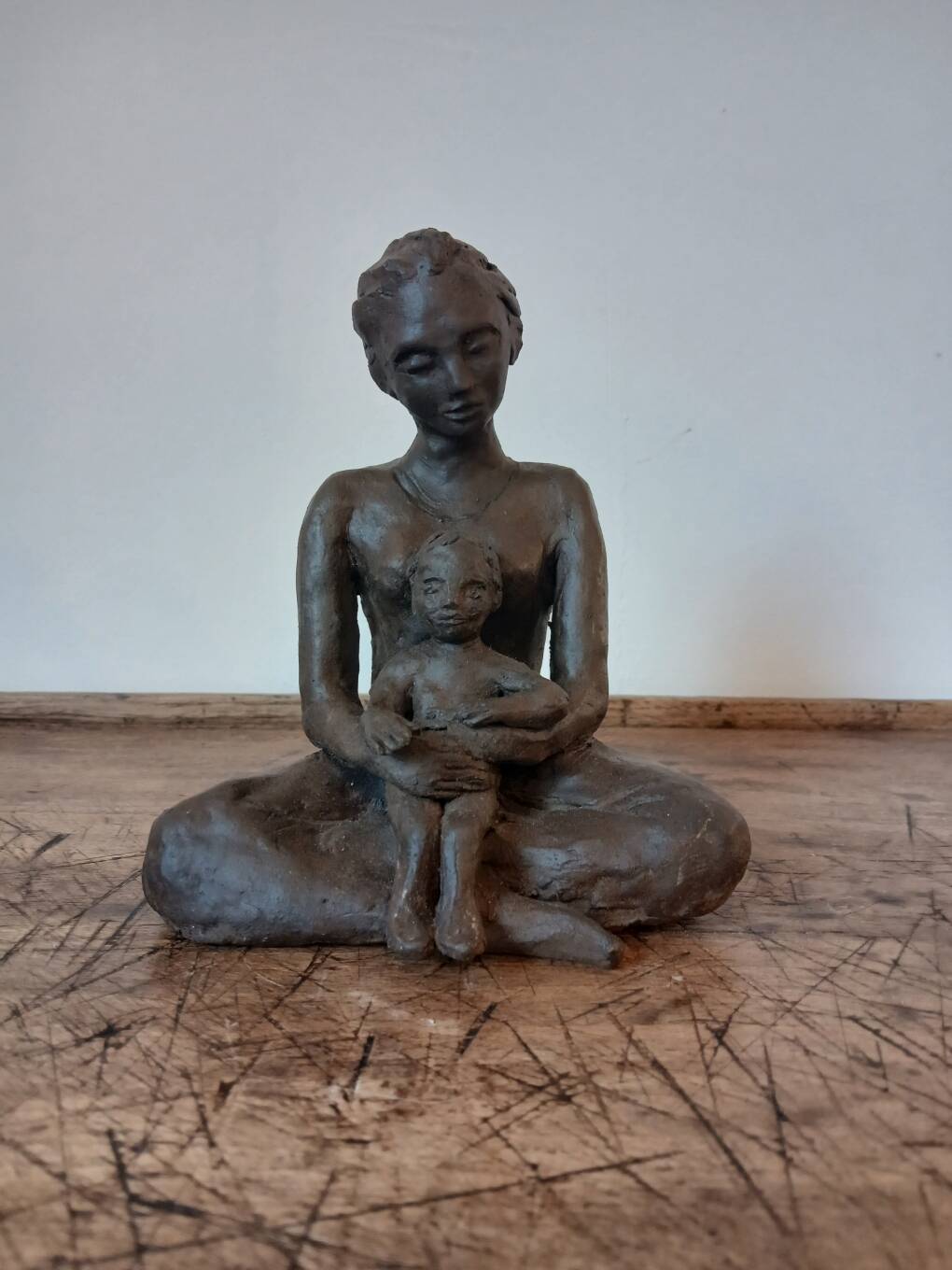 Terracotta statue of a woman with child, signed