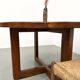 Modernist round table in solid elm, crossed legs.