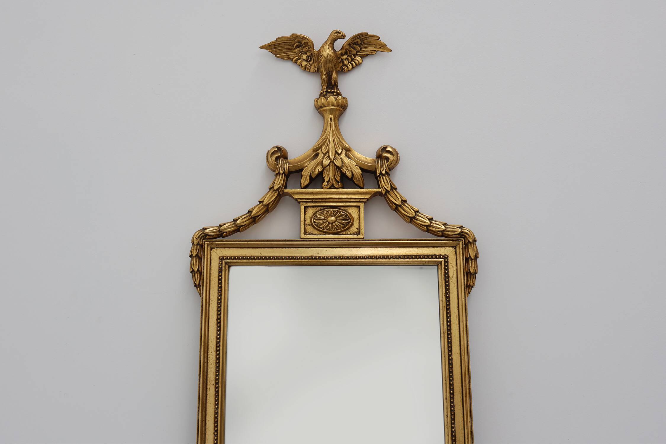 20th Century gilded wooden Empire style mirror with eagle on top