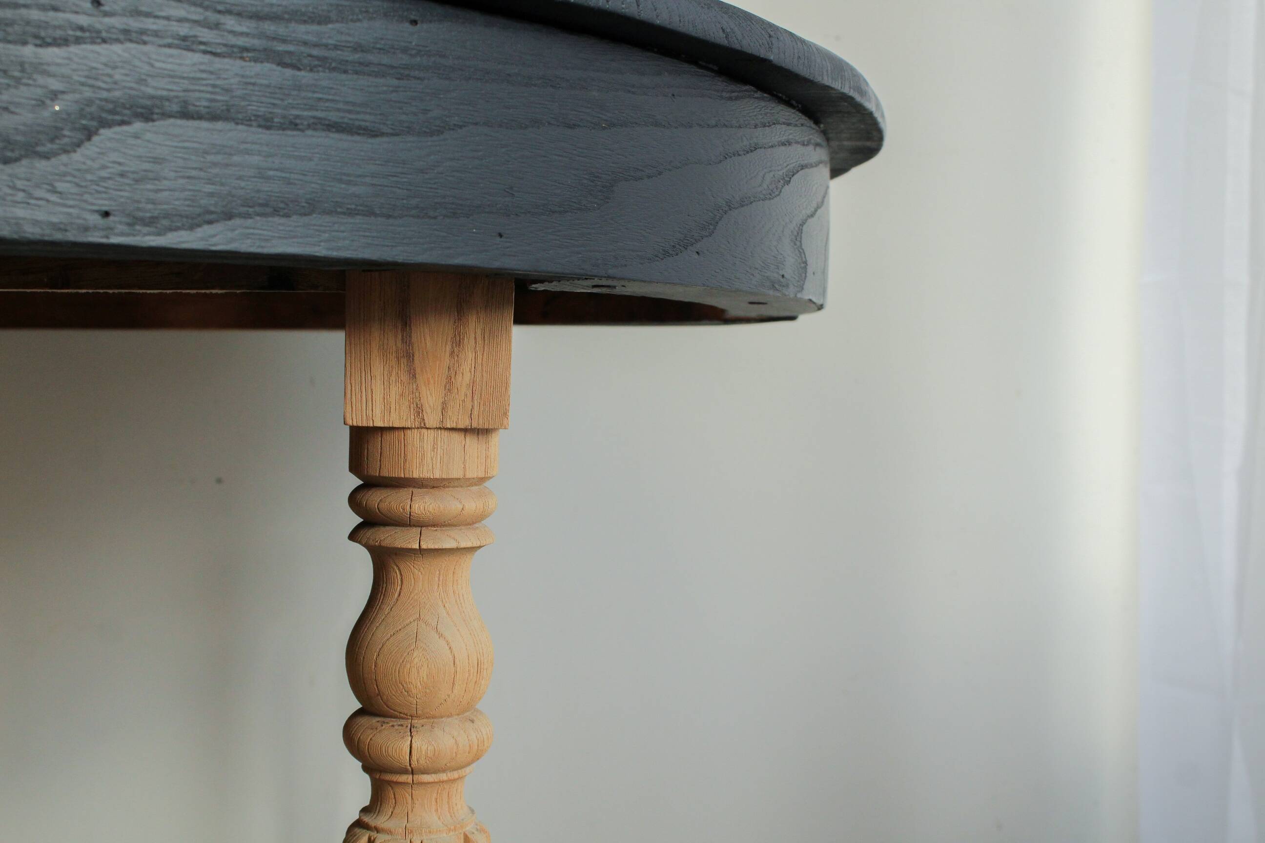 Round black dining table with oak wood.