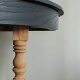 Round black dining table with oak wood.