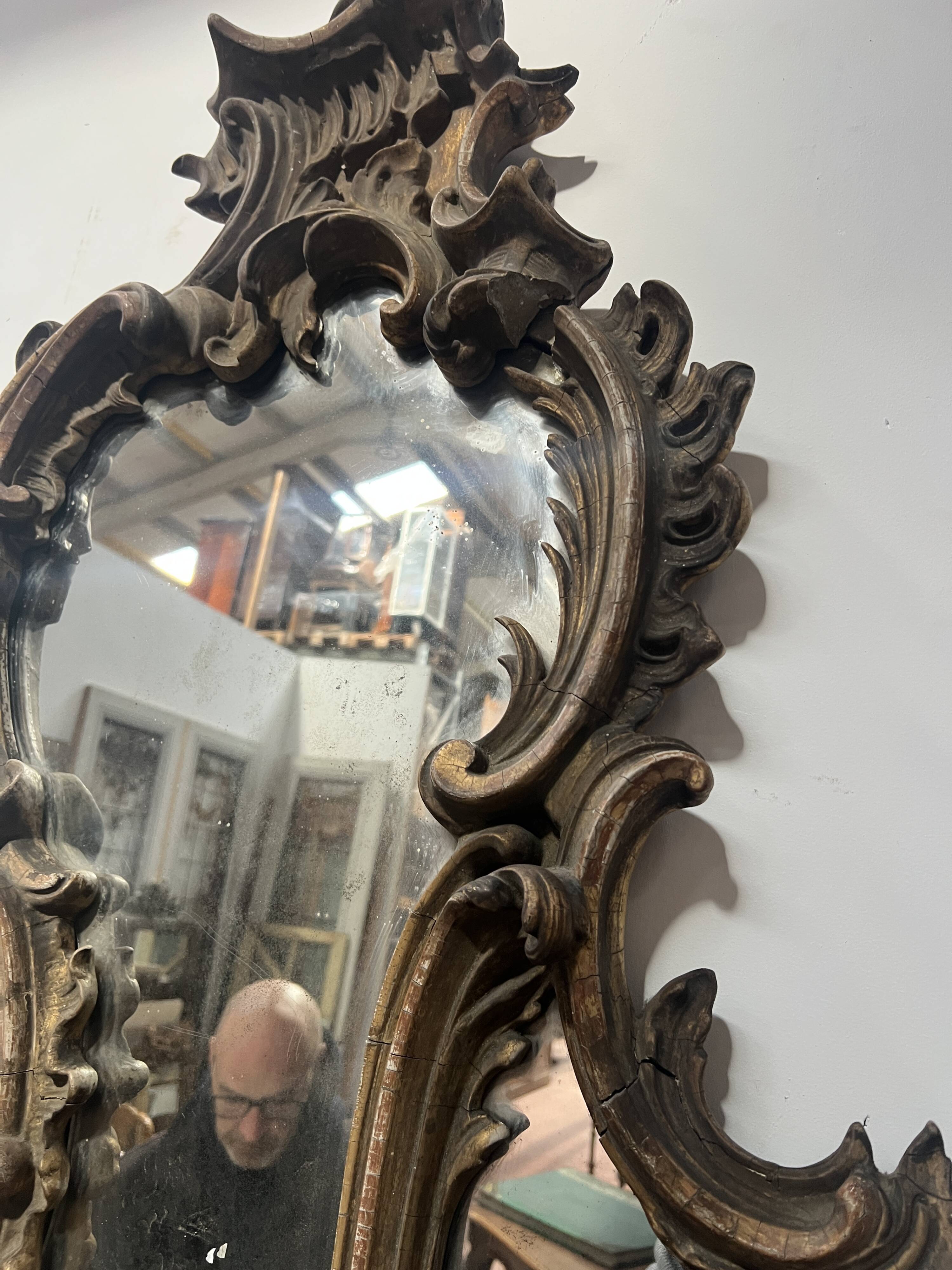 Mirror with a decorative frame featuring a four-light wall sconce, 19th century.