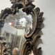 Mirror with a decorative frame featuring a four-light wall sconce, 19th century.