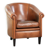 Vintage sheepskin club armchair with a warm colour scheme with black piping