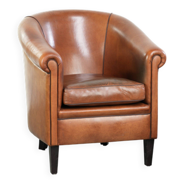 Vintage sheepskin club armchair with a warm colour scheme with black piping