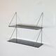Mid-century vintage shelf in a loop shape, black glass and metal.