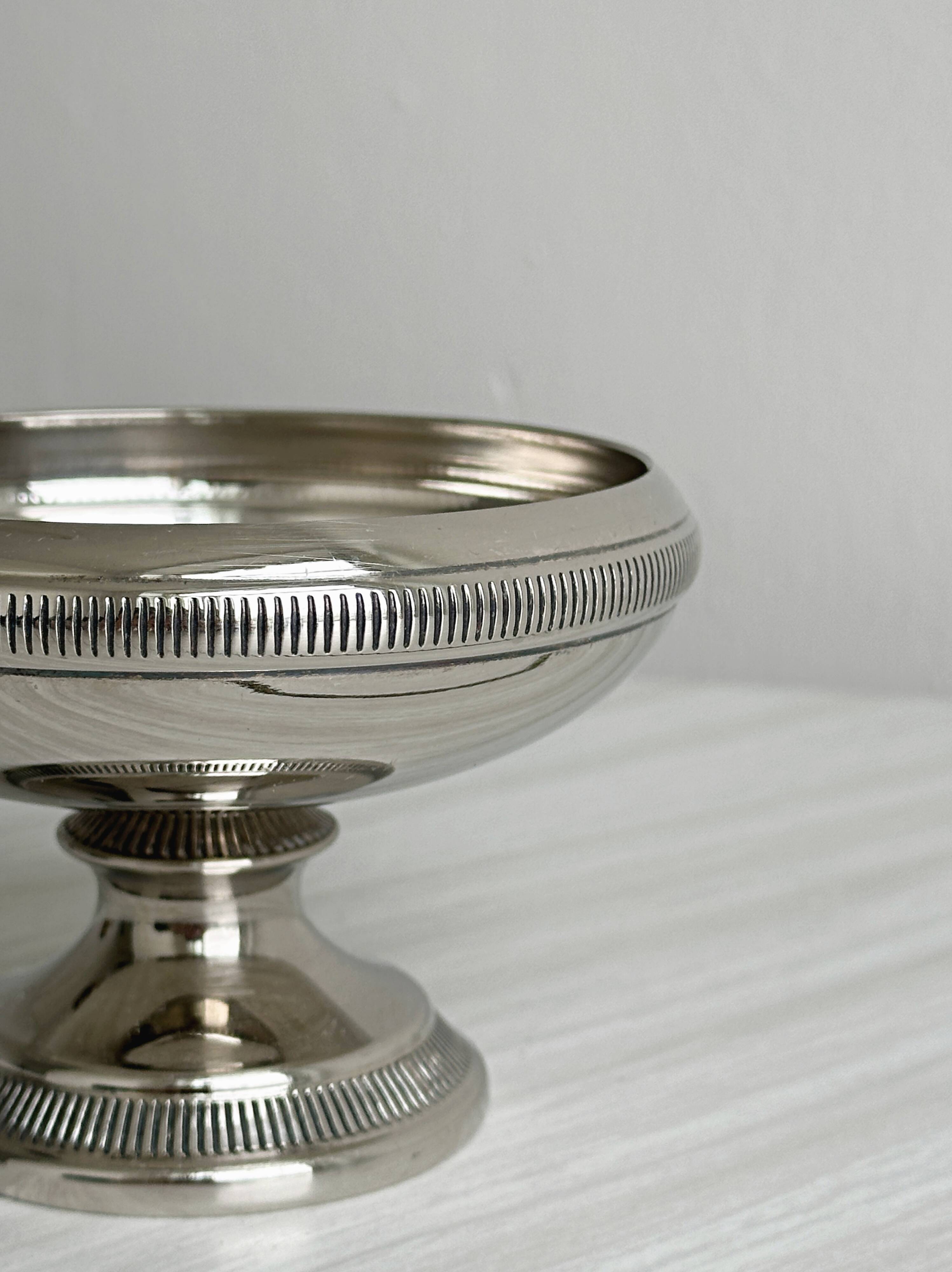 Small silver-plated metal bowl on a stand.