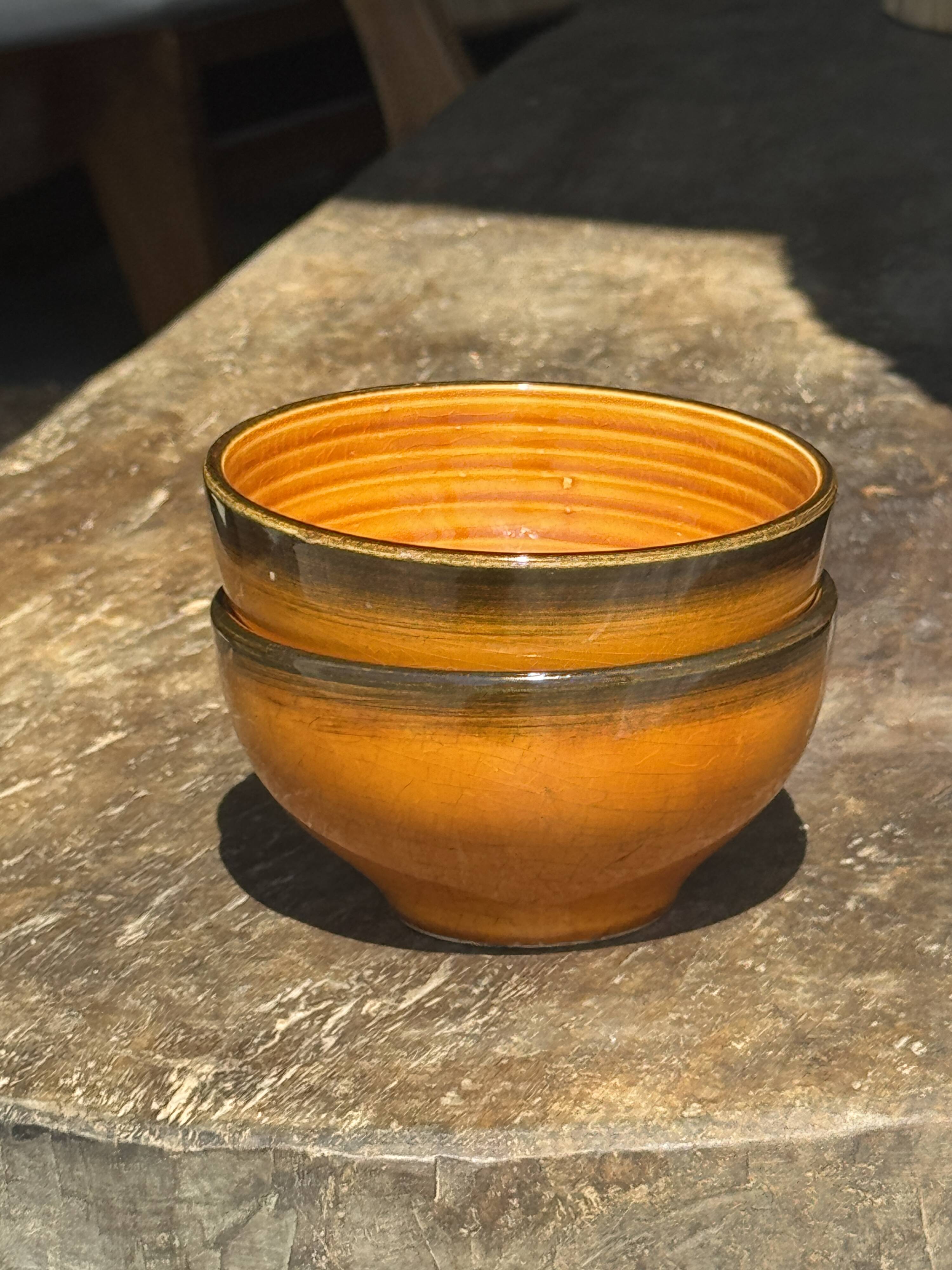 Pair of small orange bowls with black edging
